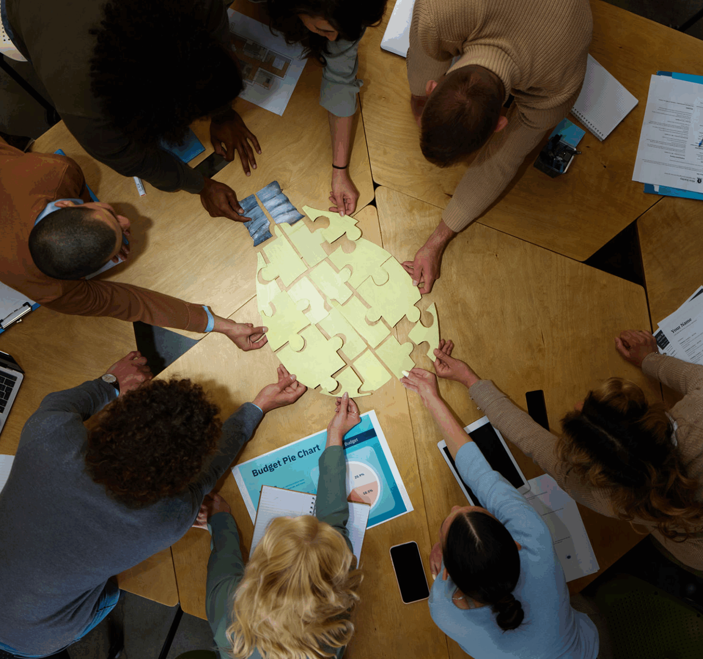 Team collaborates around a table filled with sticky notes and documents.